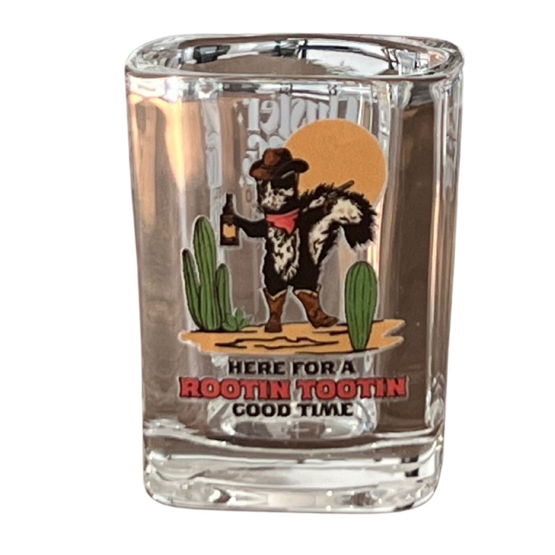 "Here For a Rootin Tootin Good Time" shot glass from Cluster Funk Studio. Fun design and well blown glass. Made in Tennessee. Art features a skunk wielding a pistol with a bottle of whiskey.