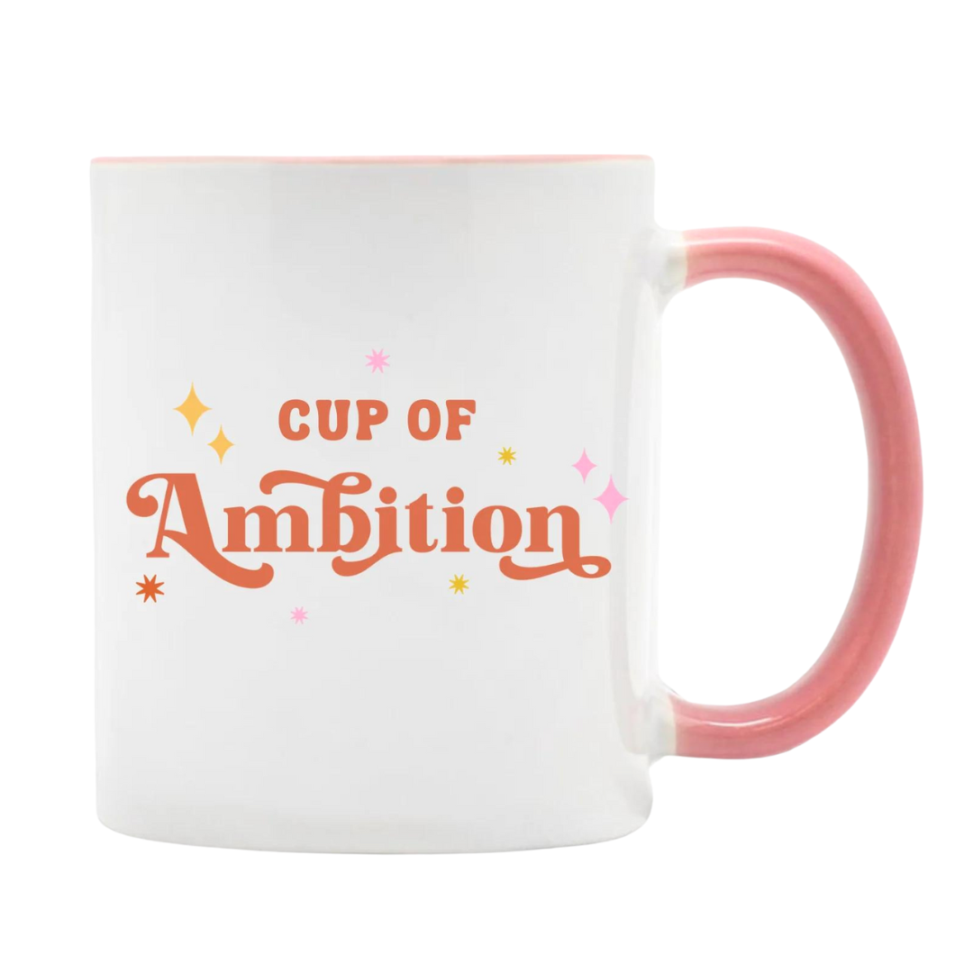 White mug says "Cup of Ambition" in pink lettering. Pink handle and a pink inside. 11 oz.