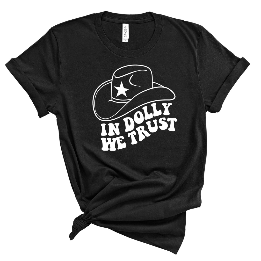 Black shirt says, "In Dolly We Trust" printed in white retro font with cowboy hat. 