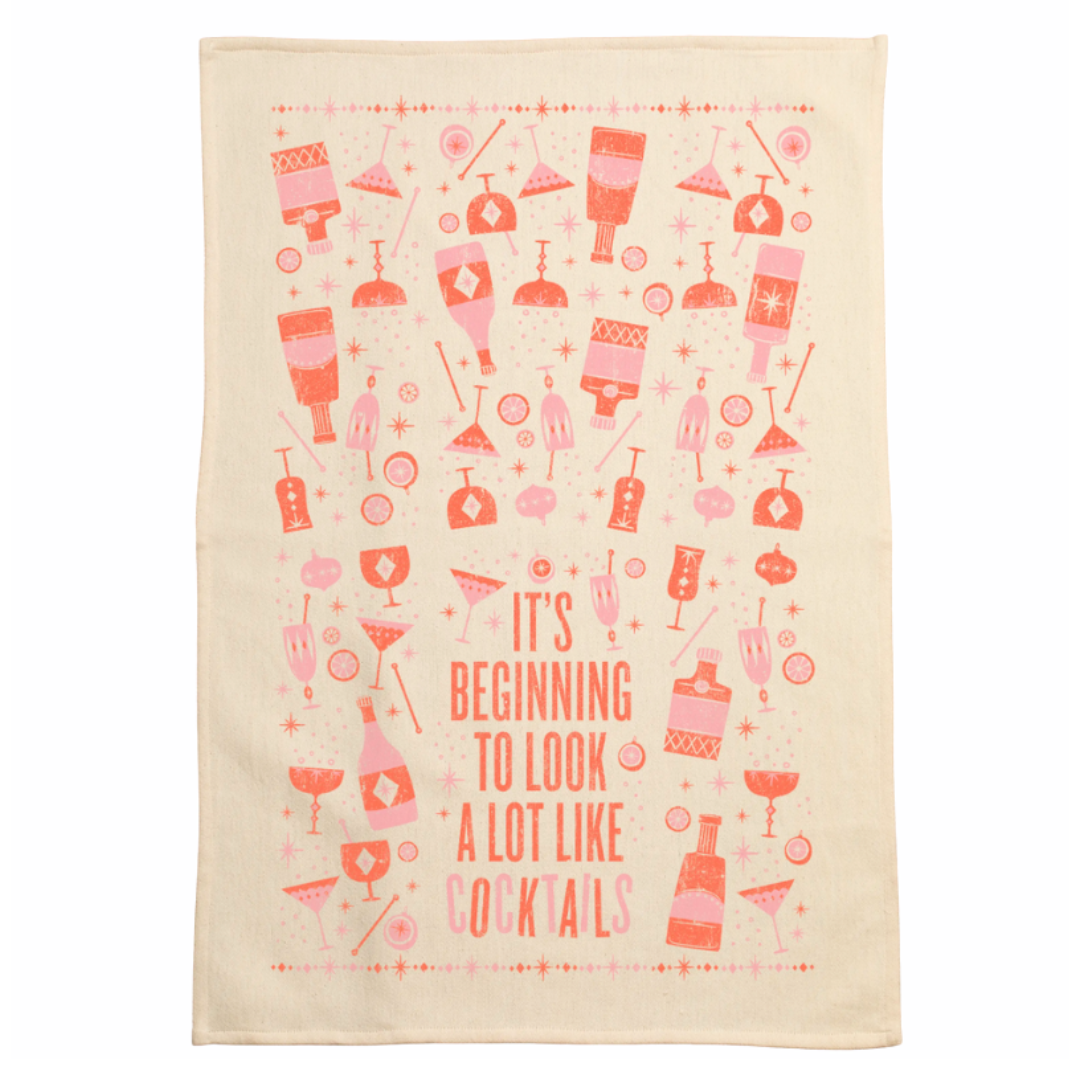 screen printed on cotton kitchen towel in pink and red, "it's beginning to look a lot like cocktails"