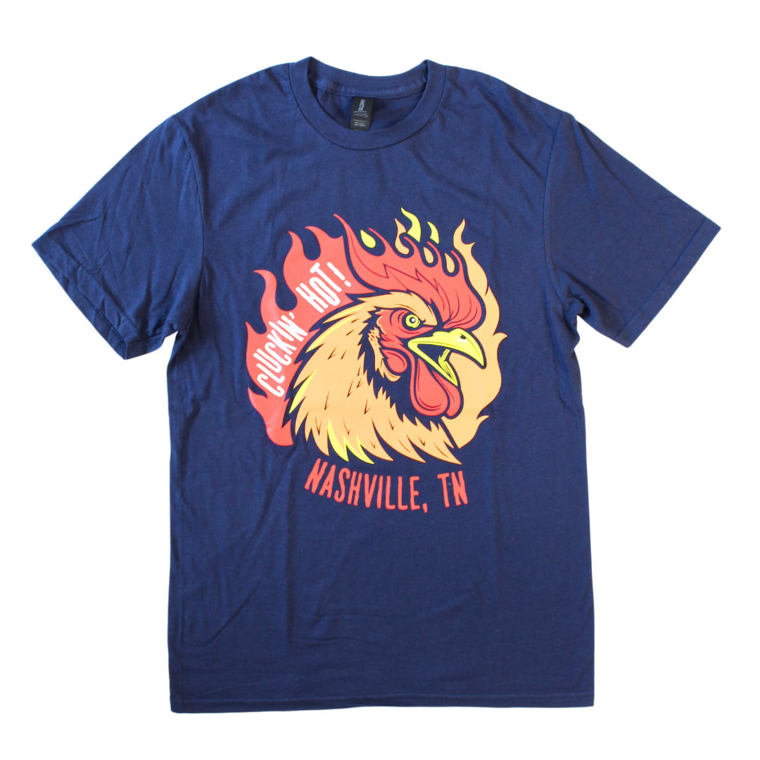 Navy shirt with chicken and flame aesthetic says, "Cluckin' Hot! Nashville TN" 