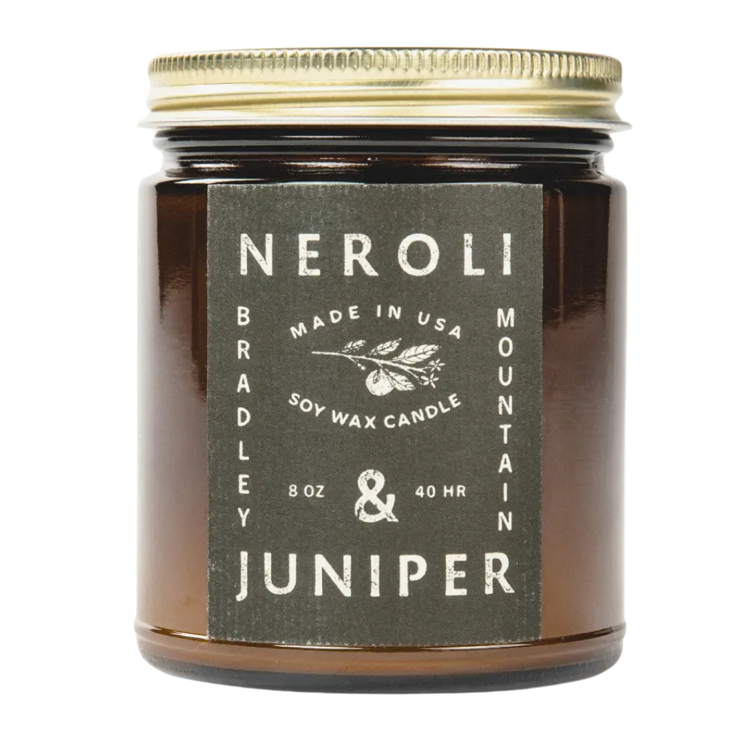 8 oz Neroli and Juniper soy wax candle with scents of, fern and aspen in an amber glass with gold lid. 
