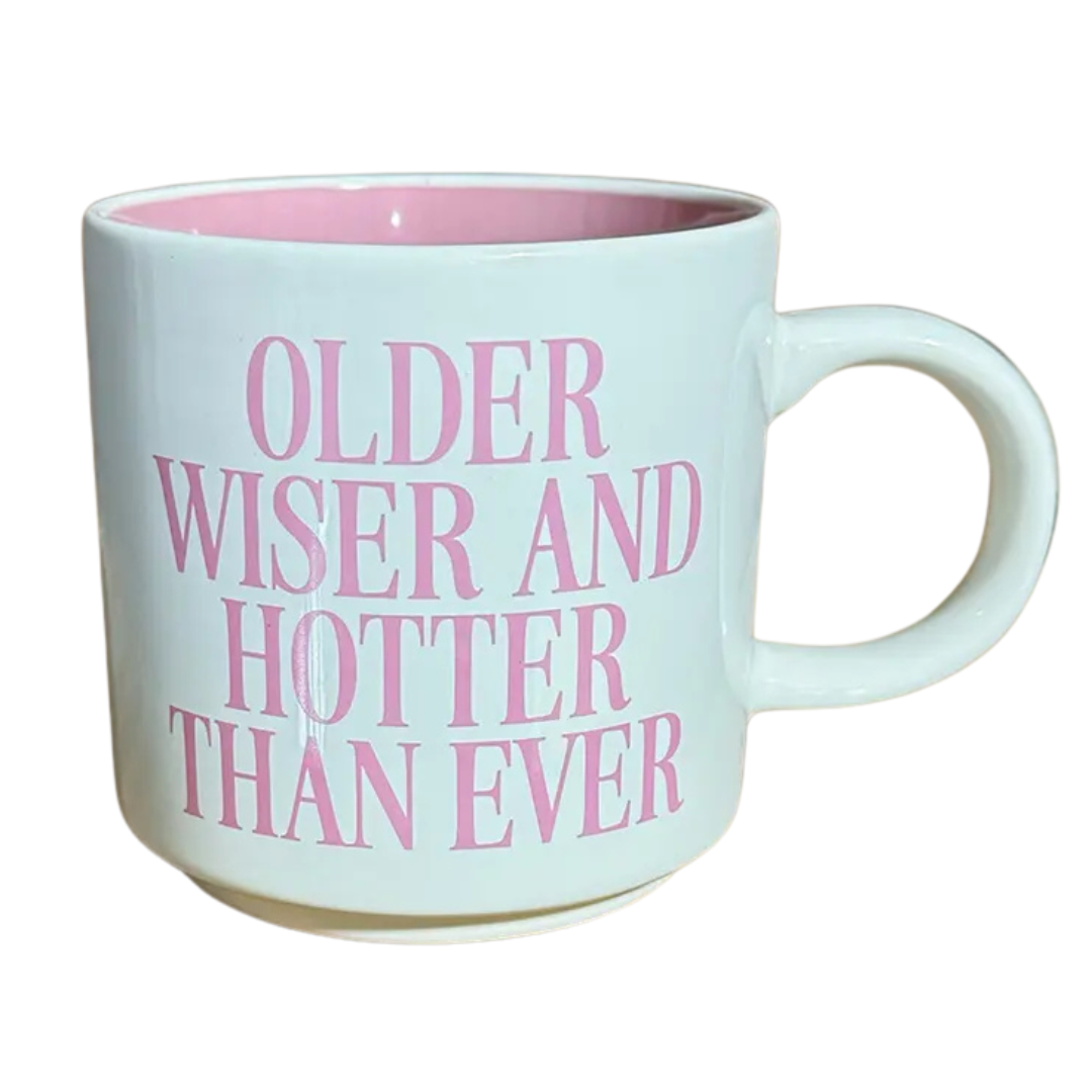 White mug with "Older Wiser And Hotter Than Ever" printed in pink letters.