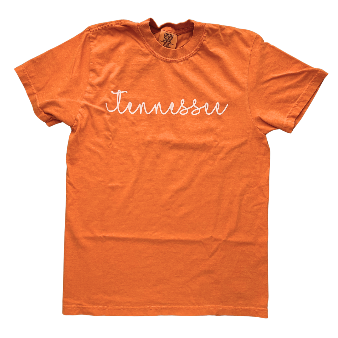 Orange shirt says, "Tennessee" screen-printed in white script. 