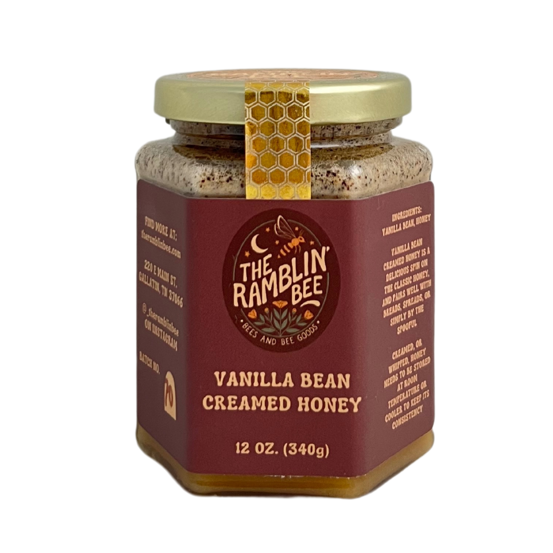 Glass jar of vanilla bean creamed honey. 12 oz. Gold lid and label with company logo and ingredients.
