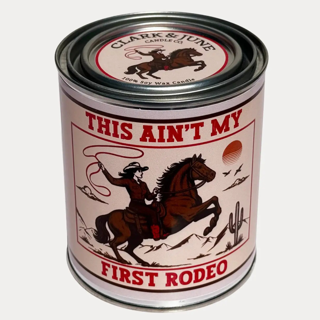 Candle label has Cowgirl on a horse with lasso. Candle comes in a paint tin canister. 