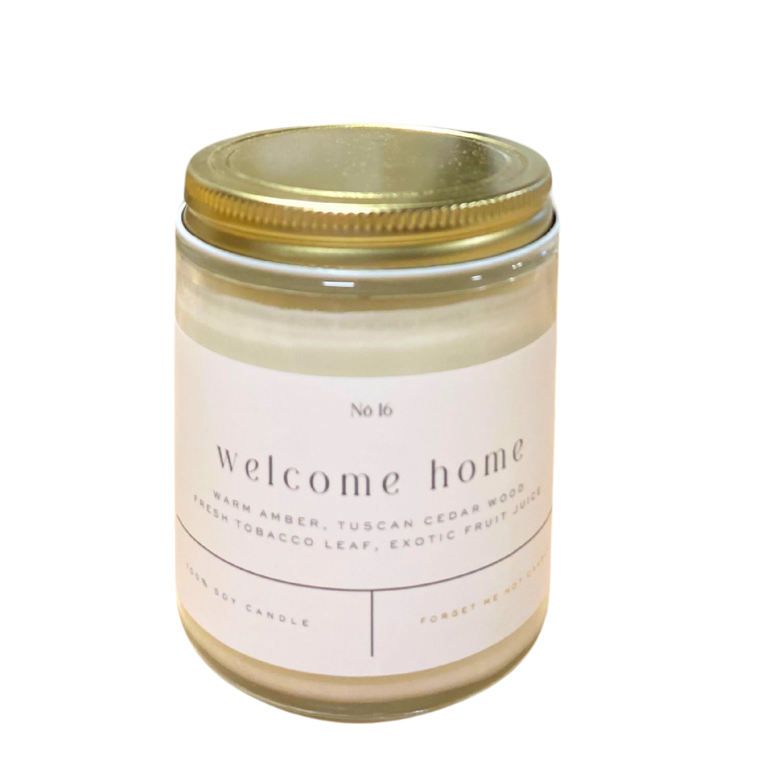 "Welcome Home" candle features the scents of warm amber, tuscan cedar wood, fresh tobacco leaf, and exotic fruit juice. 22 ounces. Forget Me Not Candle.