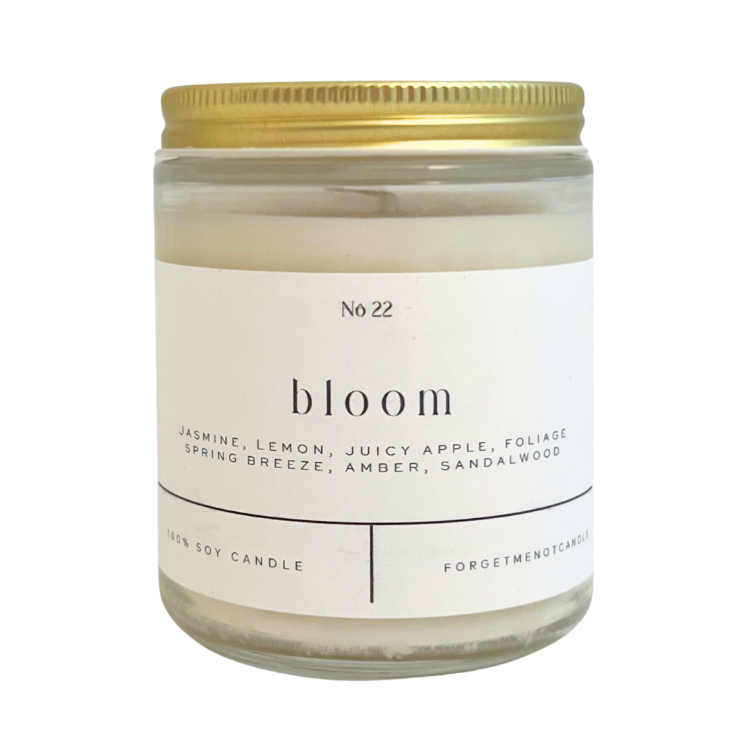 "Bloom" candle. Features the scents of jasmine, lemon, juicy apple, foliage spring breeze, amber, and sandalwood. Forget Me Not Candle.