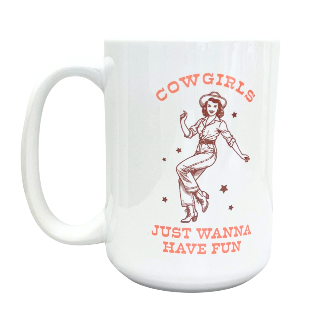 White cylinder mug. Features a minimalist cowgirl, with the phrase "Cowgirls Just Wanna Have Fun" in green lettering. White mug, white handle, and a white inside.