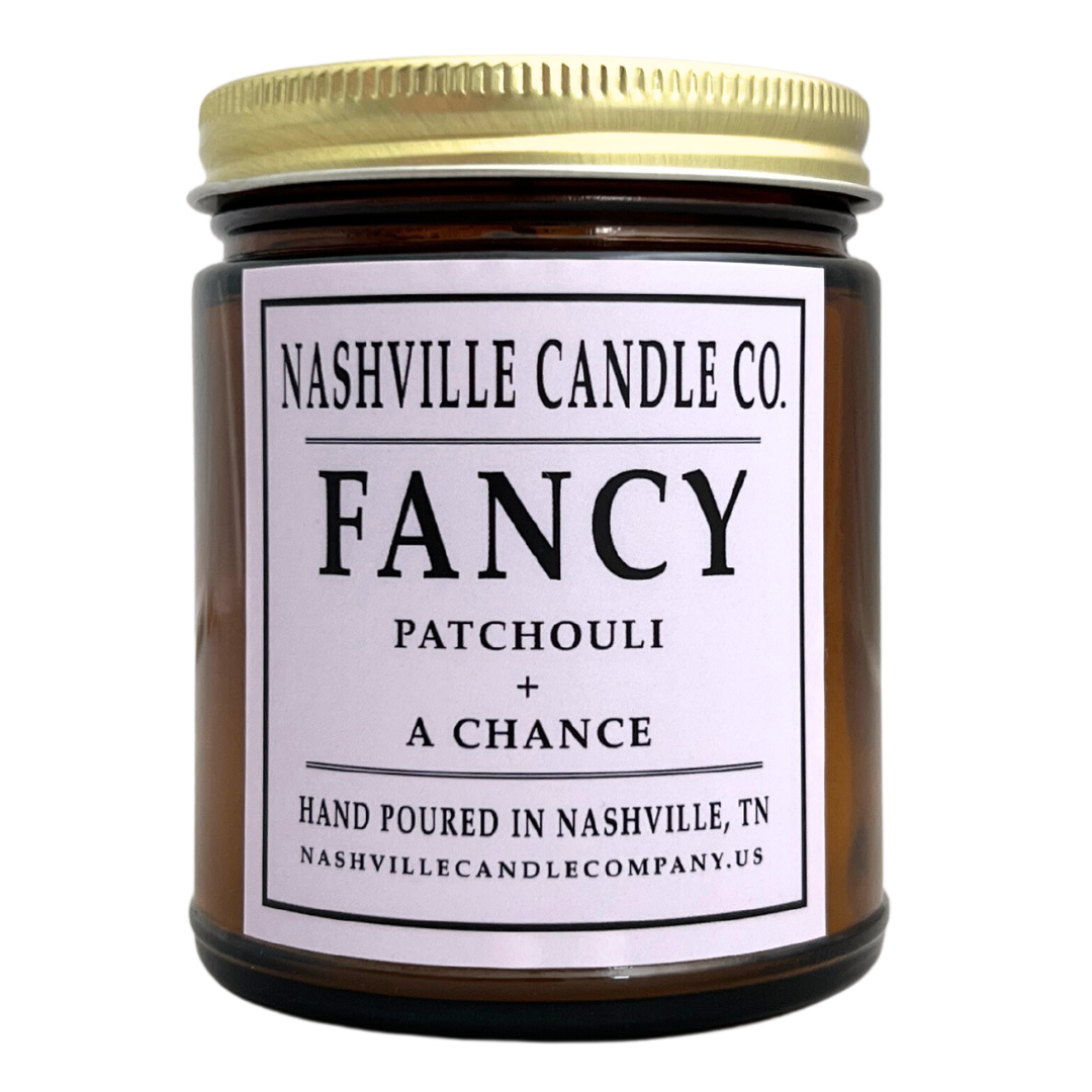 "Fancy" candle scented with patchouli and a chance, amber glass jar with lid. 