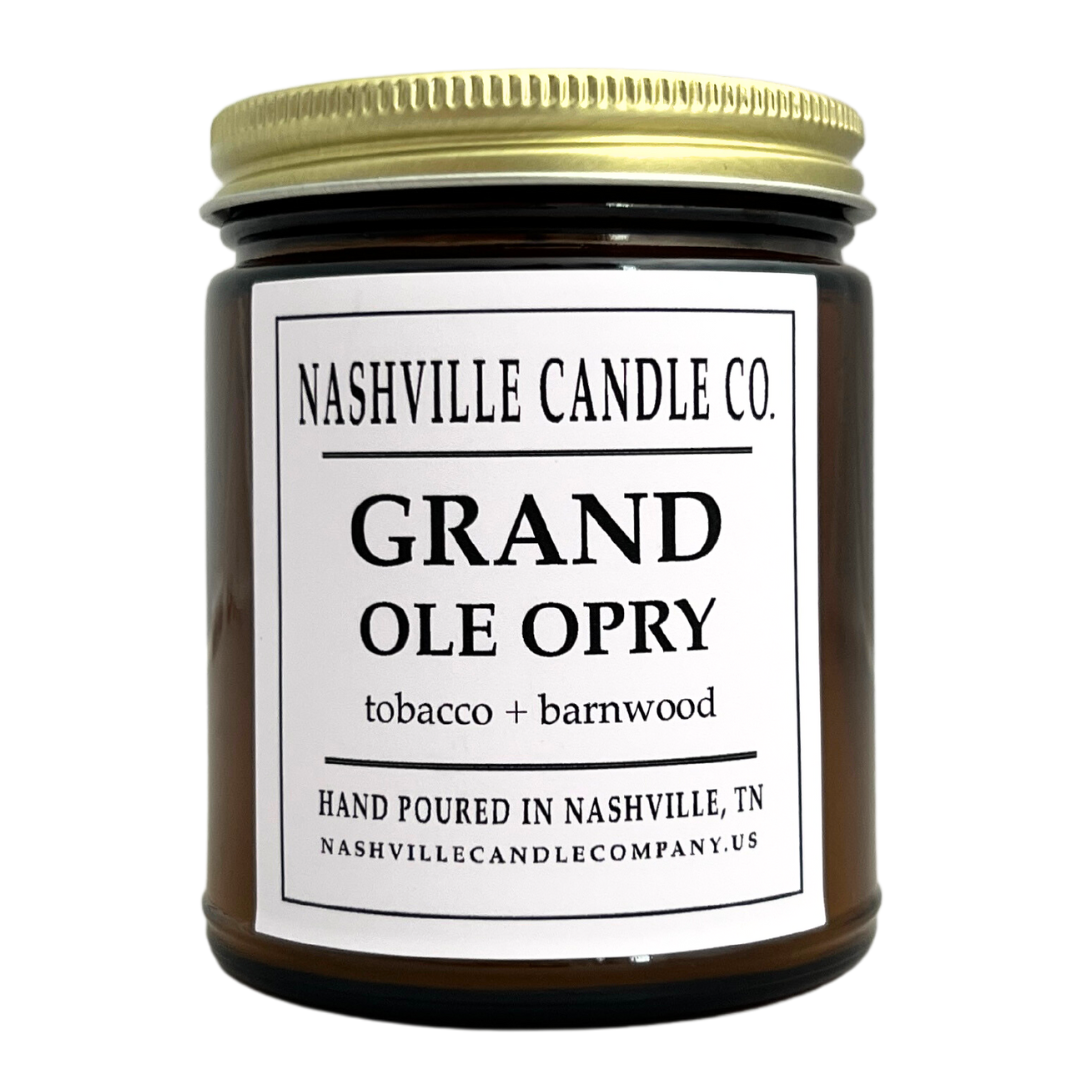 Grand Ole Opry candle scents of tobacco and barnwood, amber glass jar with lid. 