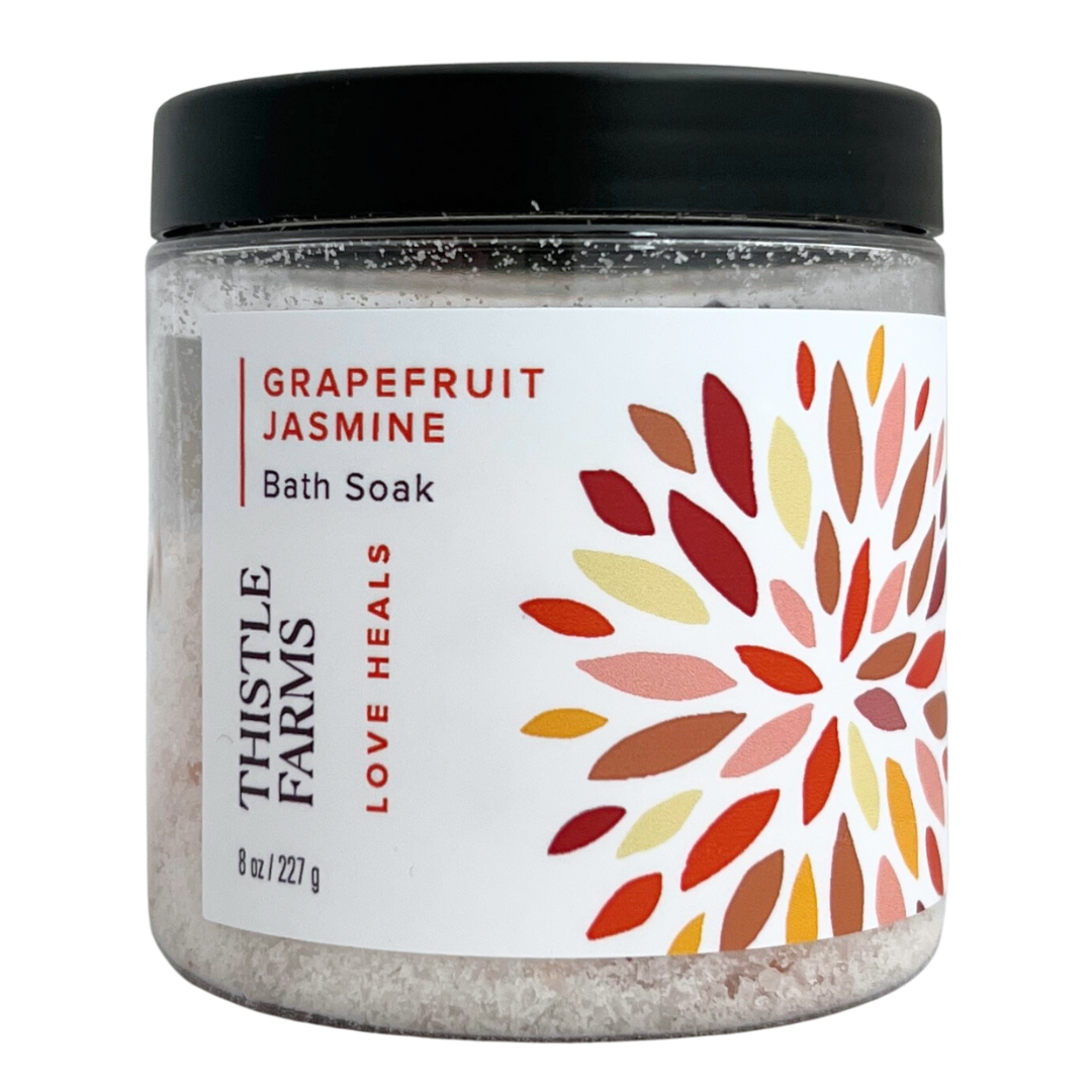 Grapefruit Jasmine bath salts in 8 oz plastic jar with black lid orange floral pattern on a white label. 