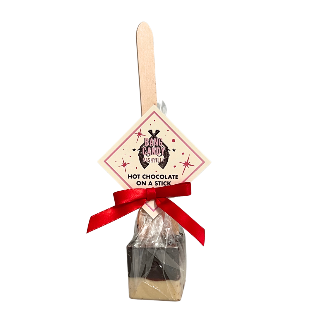 Hot chocolate on a stick. Small chocolate candy on the edge of a wooden stick. Comes with a red ribbon and label.