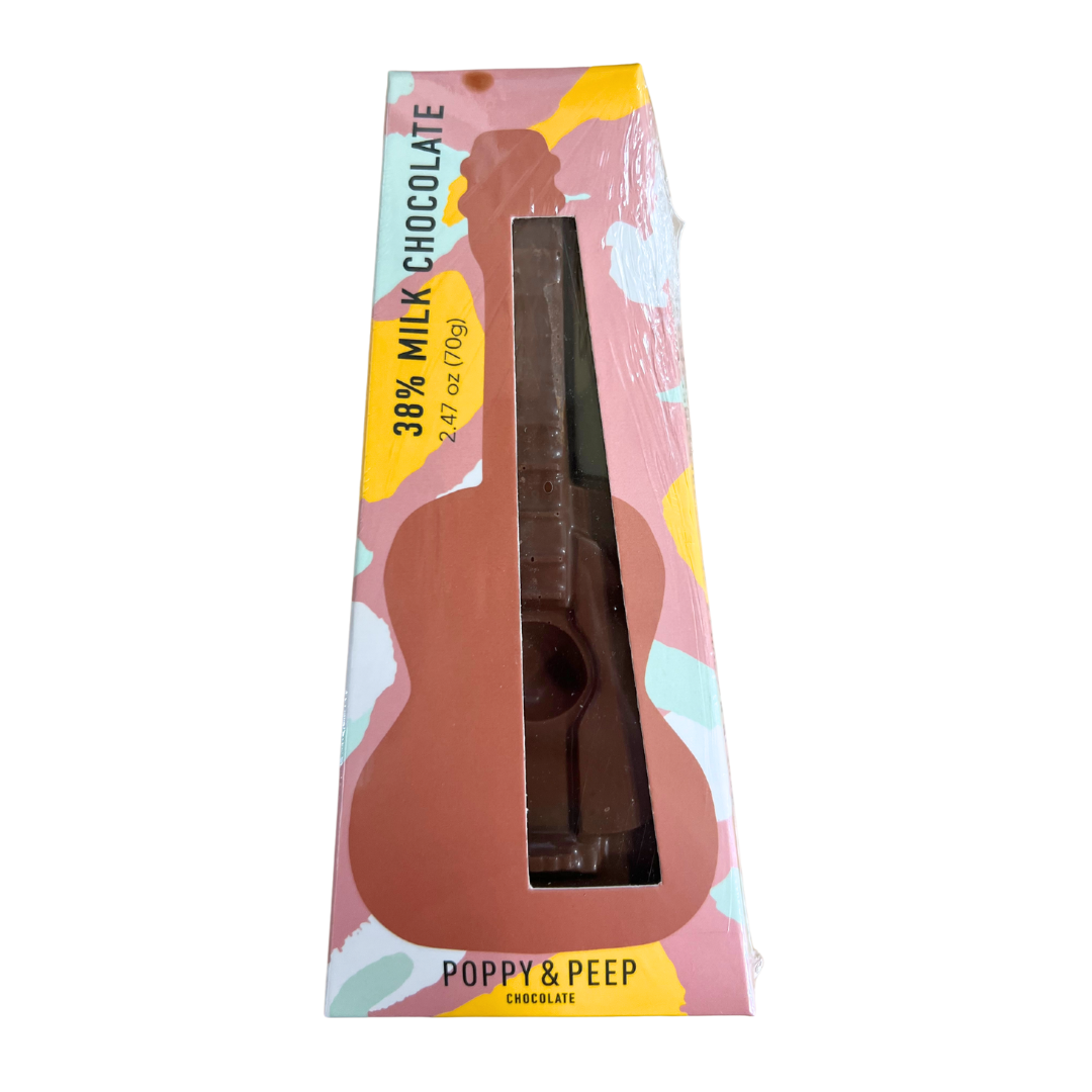 Solid milk chocolate guitar in a paper plastic wrapped box. Has a small display window to see the product.
