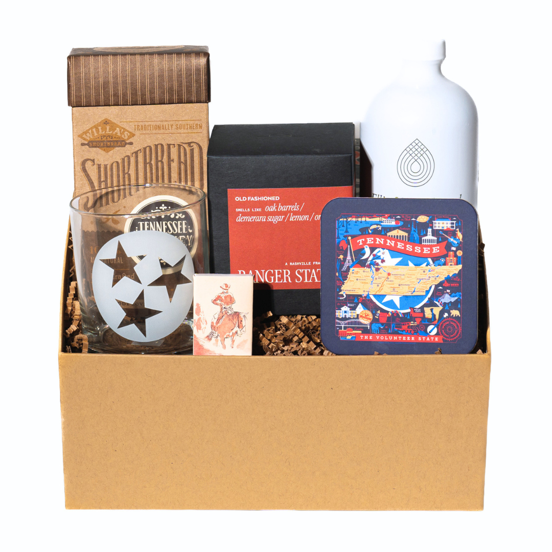 Tennessee Whiskey themed gift box with cookies, candle, rocks glass, coaster and old fashioned drink mixer. 