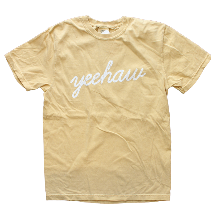 golden yellow shirt says, "Yeehaw" screen-printed in white script.